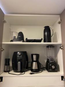 a kitchen shelf with various appliances on it at Gravatá Winterville Residence in Gravatá