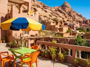a patio with a table and chairs and an umbrella at Guest house wakrim in Tafraout