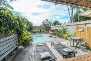 a backyard with a pool and a table and chairs at Breeze Ocean Bungalow Moorea in Moorea +11 photos