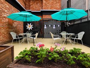 a patio with tables and chairs and blue umbrellas at SR Compact Hotel Sinchon in Seoul +27 photos