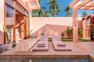 a villa with a swimming pool and two lounge chairs at Villa Solea in Gili Trawangan