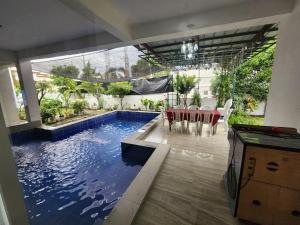 a swimming pool in a house with a table and chairs at Angeles Private Pool Villa in Angeles