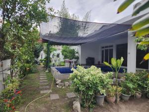 a house with a garden with plants in the yard at Angeles Private Pool Villa in Angeles