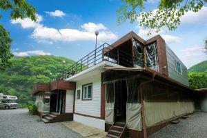 a house with a balcony on top of it at gapyeong semmul pension in Gapyeong