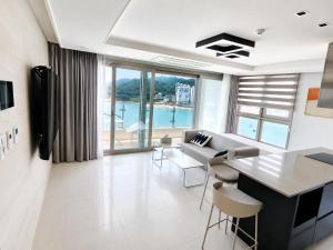 a living room with a couch and a table and chairs at Elmomento Songdo in Busan