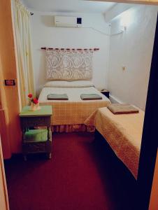 a small room with two beds and a table at Doña Minina in Posadas