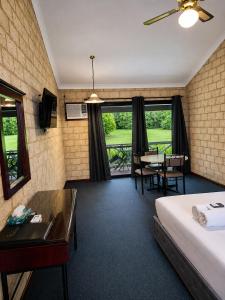 a hotel room with a bed and a table and chairs at Karri Forest Motel in Pemberton