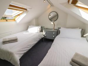 two beds in a attic bedroom with a mirror at Florence Villas in Worcester