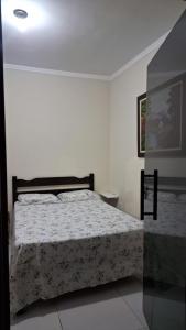 a bedroom with a bed in a white room at Suíte privativa com acesso à rua in Dourados