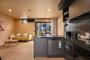 a kitchen with a counter and a living room at Ski Villa with Carpark 40, Stylish Alpine Base in Queenstown