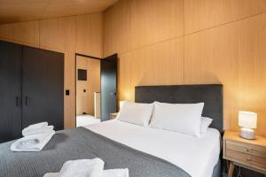 a bedroom with a large bed with white pillows at Ski Villa with Carpark 40, Stylish Alpine Base in Queenstown +7 photos