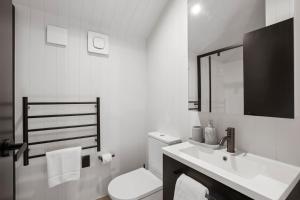 a white bathroom with a toilet and a sink at Ski Villa with Carpark 40, Stylish Alpine Base in Queenstown