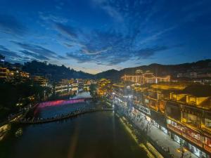 a view of a river in a city at night at First encounter with a homestay in Fenghuang County