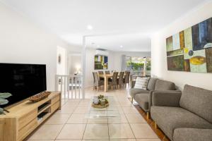a living room with a couch and a tv at Skippers Place in Noosaville