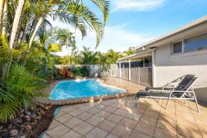 a patio with a pool and a chair next to a house at Skippers Place in Noosaville
