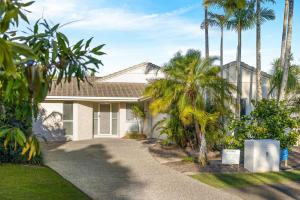 a house with palm trees in front of it at Skippers Place in Noosaville