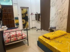 a bedroom with a yellow bed and a mirror at Legacy Yumai in Kuala Rompin