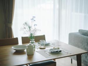 a dining room table with a vase of flowers on it at Green Peak 2 in Aso +37 photos