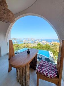 a wooden table and chairs in a room with a window at Oh!Julia Hotel Komodo in Labuan Bajo