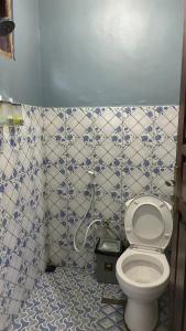 a bathroom with a toilet and blue and white tiles at Cendana Guesthouse Labuan Bajo2 in Labuan Bajo