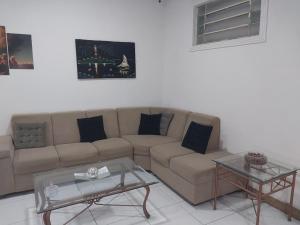 a living room with a couch and two tables at Fênix hospedaria in Natal