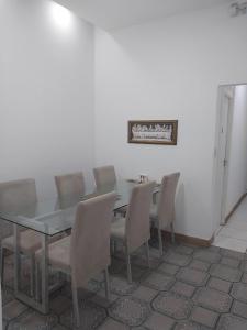 a dining room with a glass table and chairs at Fênix hospedaria in Natal