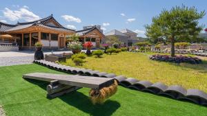 a park with a bench in front of a building at Hanok Stay ieum in Gangneung