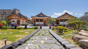 a stone path in front of a house with a building at Hanok Stay ieum in Gangneung