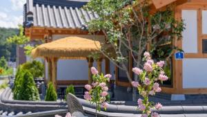 a building with pink flowers in front of it at Hanok Stay ieum in Gangneung +57 photos