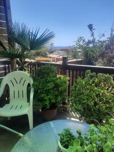a table and a chair on a balcony with plants at Loft vista a la bahía in Valparaíso +5 photos