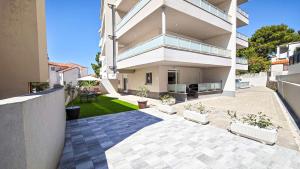 a large white house with a patio and a yard at Apartments Danica in Promajna