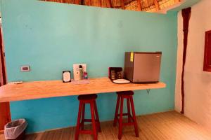 a counter with two bar stools with a microwave on it at Cabanas Jaalkab in Chelem