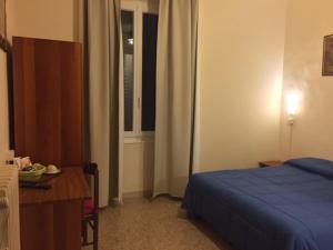 um quarto com uma cama, uma secretária e uma janela em Affittacamere Euro em Ancona