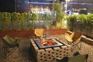 a backyard with a fire pit and chairs and a building at Stay Suncheon in Suncheon