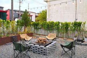 a backyard with a fire pit and chairs and a fence at Stay Suncheon in Suncheon +14 photos