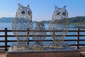 a metal sculpture of three owls sitting on a fence at Seocheon Water Willow Pension in Seocheon