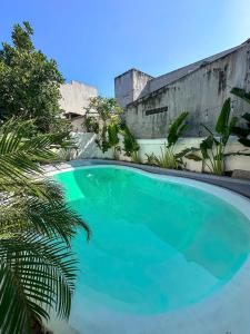 a large blue swimming pool next to a wall at Dune House Phan Thiết in Ấp Bình Hưng +14 photos