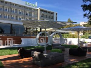 un patio dell'hotel con sedie e ombrellone di Oxygen Lifestyle Hotel a Rimini
