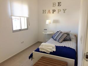 エステポナにあるTop Floor Esteponaのベッドルーム1室(壁にハッピーサイン付きのベッド1台付)