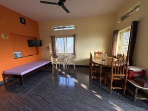a living room with a table and a dining room at Cave View Homestay in Badami