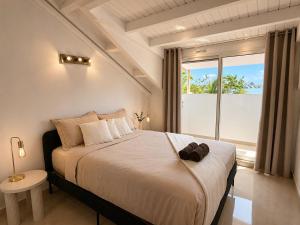a bedroom with a large bed with a large window at Sunset Paradise in Baie Nettle +19 photos