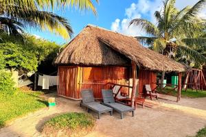 a small hut with chairs and a straw roof at Cabanas Jaalkab in Chelem