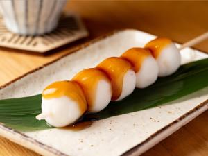 a row of food on a plate on a table at Hotel Kanazawa Zoushi in Kanazawa