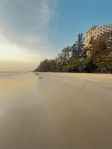a sandy beach with a building in the background at NJ HOME Pool Villa in Ban Phe