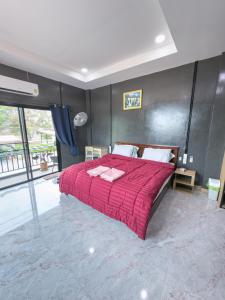 a bedroom with a large bed with a red comforter at NJ HOME Pool Villa in Ban Phe +90 photos