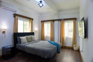 a bedroom with a bed and two windows at Green Valley Luxe Apartments in Kingstown