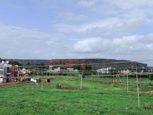 a view of a field with a hill in the background at Cave View Homestay in Badami +5 photos