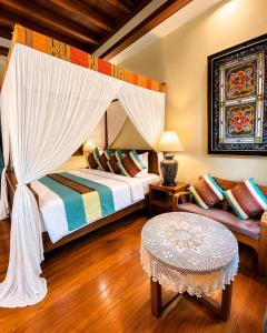 a bedroom with a canopy bed and a table at Amatalannavillage Chiangmai in Chiang Mai +89 photos