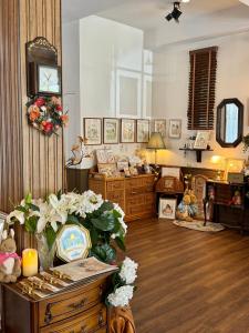 a living room with a table with flowers on it at LA BURIE HOTEL Chiang Mai in Chiang Mai