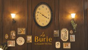 a clock is hanging on a wall with pictures at LA BURIE HOTEL Chiang Mai in Chiang Mai +28 photos